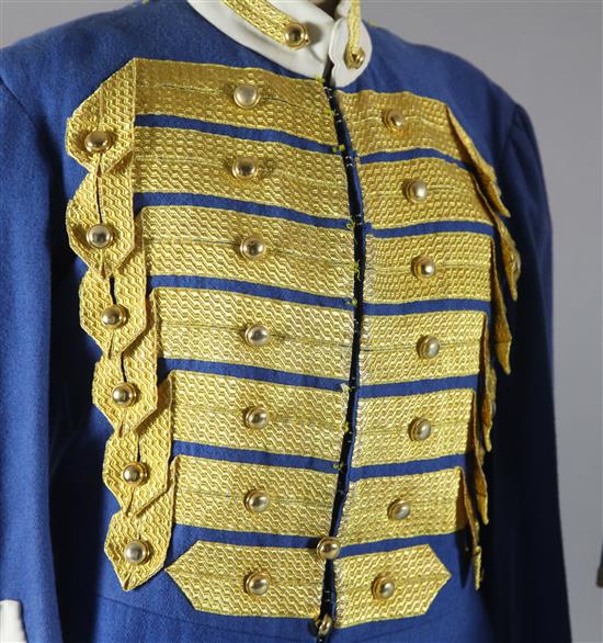 Rigoletto: A rail with a pale blue skirt and jacket, a quantity of royal blue gold braided jackets and trousers,